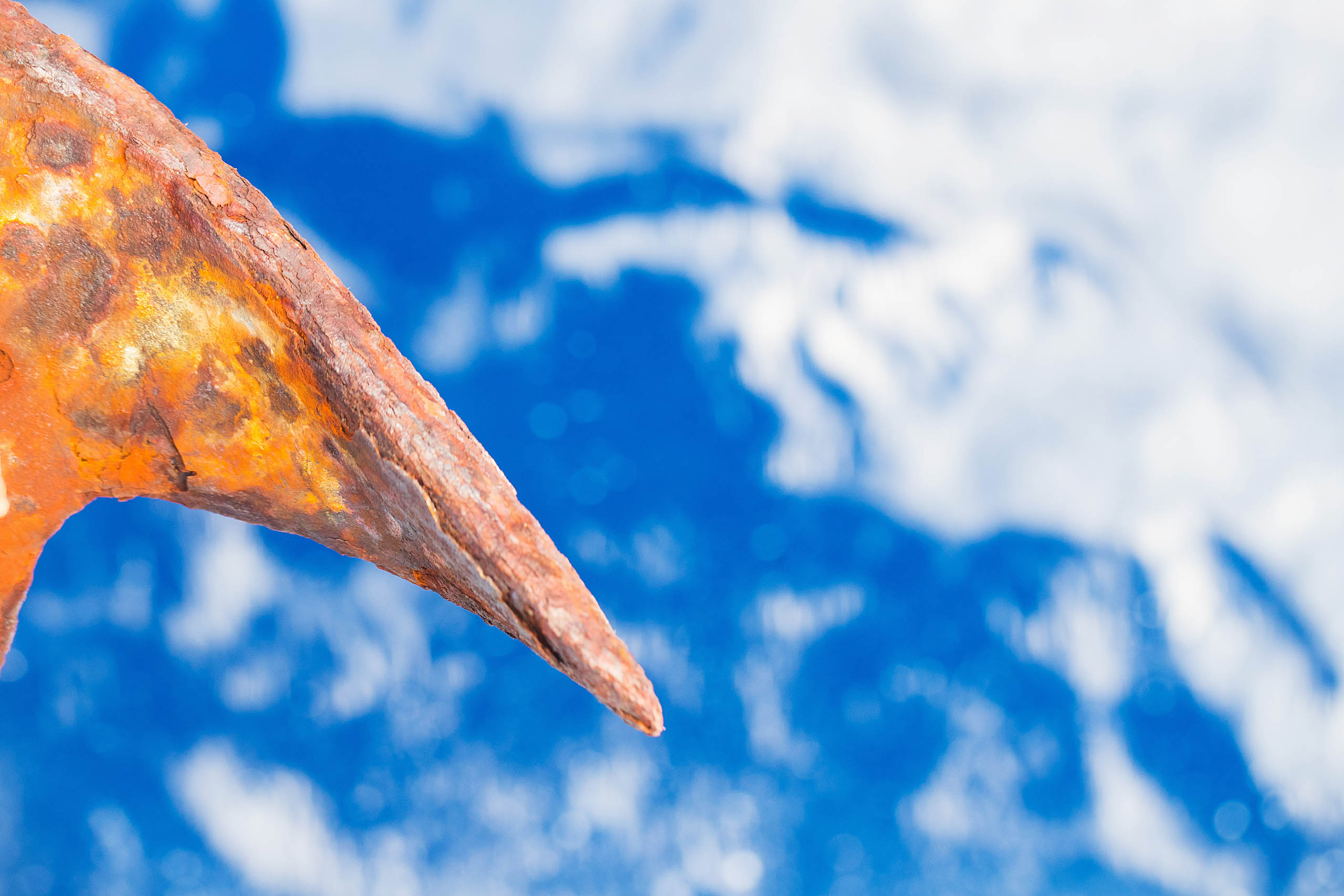 Rusty iron anchor over deep blue ocean