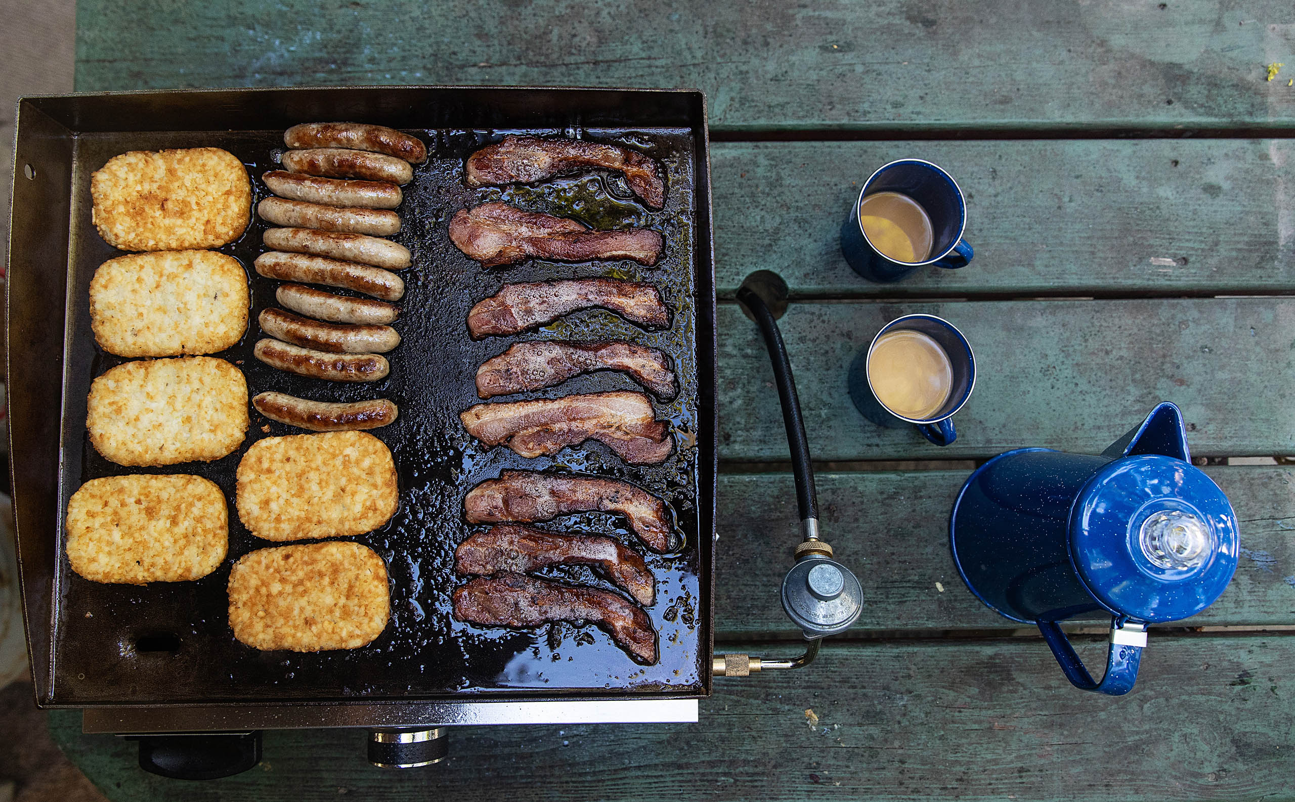 Fresh pot of coffee with bacon, sausage and hashbrowns cooking o